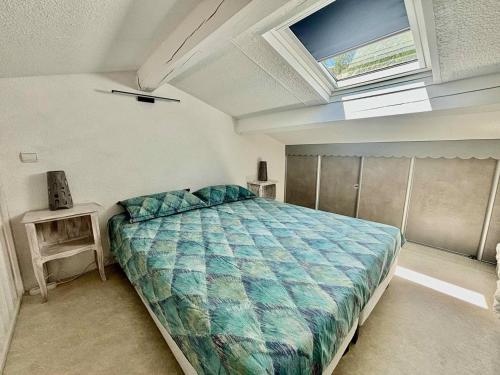 une chambre avec un lit et une lucarne dans l'établissement Appartement rénové : Clim, Piscine et Vue Mer - FR-1-816-28, à Bormes-les-Mimosas
