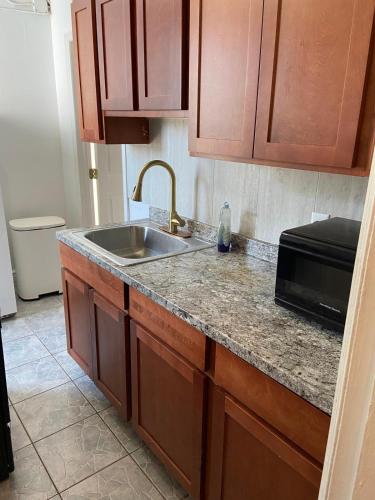 a kitchen counter with a sink and a microwave at C Jay Homes 6 minutes Walk to Journal square in Jersey City