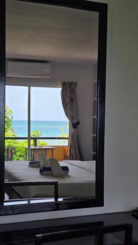 a mirror reflecting a bedroom with a view of the ocean at Beach Villa Hotel Maldives - hotel by the beach in Dhiffushi