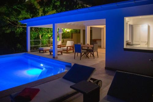 a house with a swimming pool at night at Private Escape Villa near Beach and Shopping in Quartier de Lorient