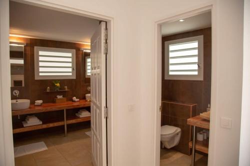a bathroom with a toilet and a sink at Private Escape Villa near Beach and Shopping in Quartier de Lorient