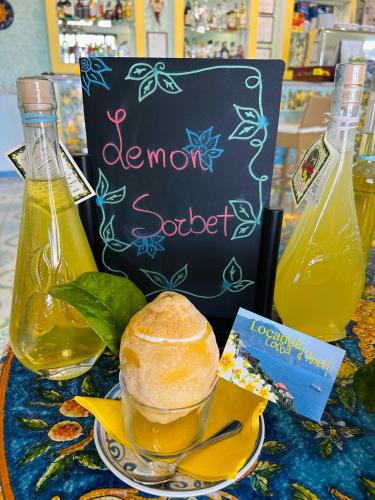 a sign with a bowl of bread and a bottle of orange soda at Locanda Costa D'Amalfi in Amalfi