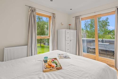 a tray of fruit on a bed in a bedroom at House 3 in Looe