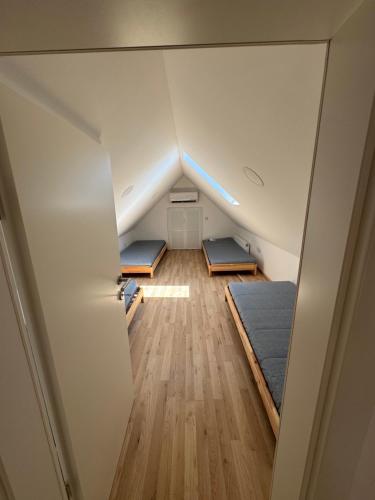 an attic bedroom with three mattresses and a bed at Apartmaji Vanja in Gradac