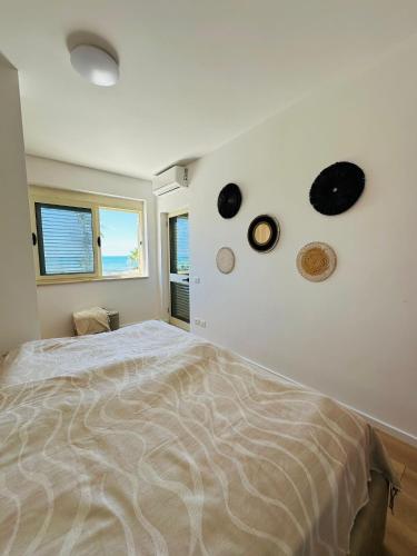 a bedroom with a bed and clocks on the wall at Manta Apartment Albania in Golem