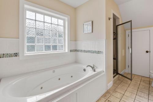 a white bath tub in a bathroom with a window at 8th And Sound in Corolla