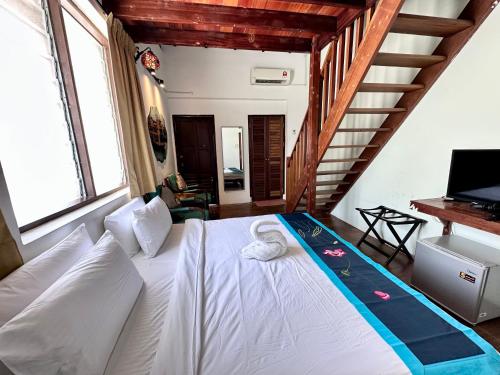 a bedroom with a white bed and a staircase at 26 Rangoon Residence 26 in George Town