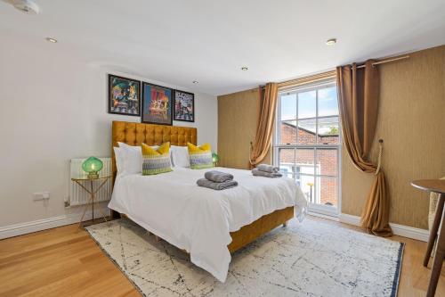 a bedroom with a large bed and a large window at Entire City Centre one bedroom Apartment- Self check in FREE PARKING in Chichester
