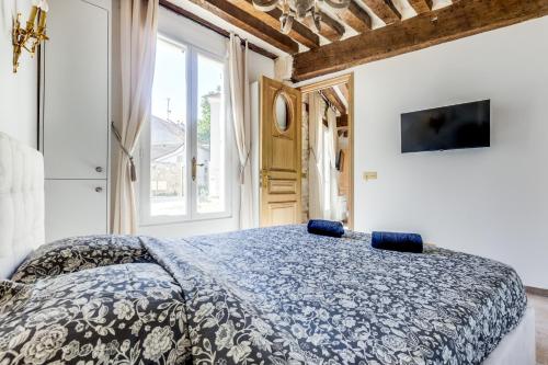 une chambre avec un lit avec une couette bleue et blanche dans l'établissement Le Clos du Four, à Saint-Maur-des-Fossés