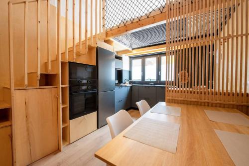 a kitchen with a wooden table and a kitchen with a staircase at Suances Surf Beach in Suances