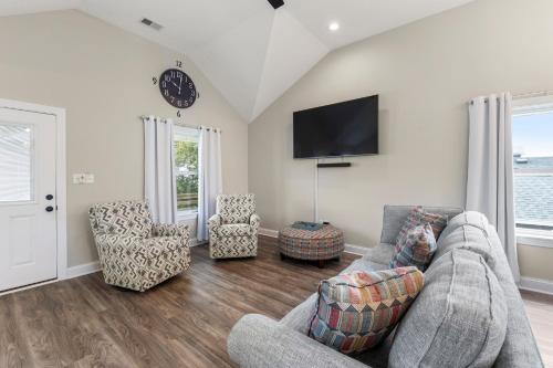 a living room with a couch and two chairs at Masons Beach House Getaway in Kill Devil Hills