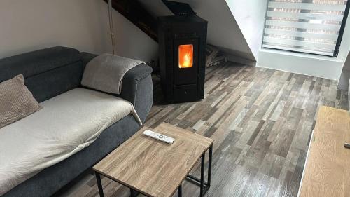 a living room with a couch and a wood stove at Appartement 3 chambres in Faverges