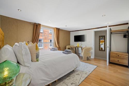 a bedroom with a large white bed and a television at Entire City Centre one bedroom Apartment- Self check in FREE PARKING in Chichester