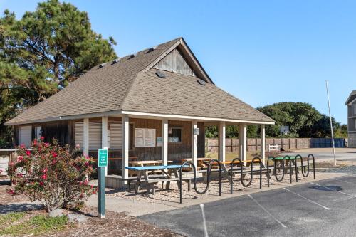 a gazebo with tables and chairs in a parking lot at 8th And Sound in Corolla