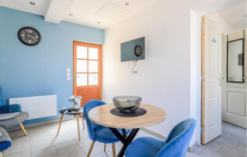 a dining room with blue chairs and a table at Jolie Maison Proche Plage in Le Crotoy