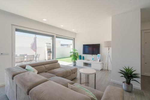 a living room with a couch and a table at Casa Ventosa with private pool in Mariquiteira