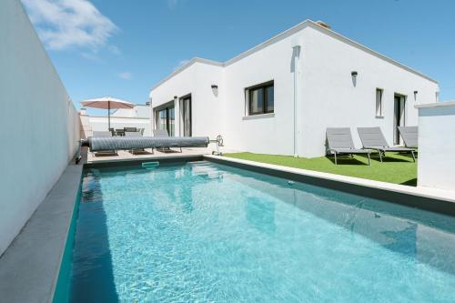 a swimming pool in front of a house at Casa Ventosa with private pool in Mariquiteira