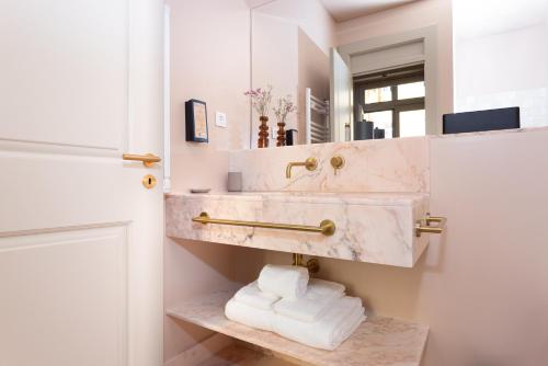 a bathroom with a marble sink and a mirror at Hermitage Castelo - Casa Sé in Lisbon