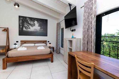a bedroom with a bed and a desk and a television at La Pineta del Borgo in Ravenna