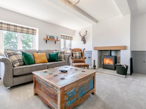a living room with a couch and a fireplace at Clearview - Cottage in Barlow