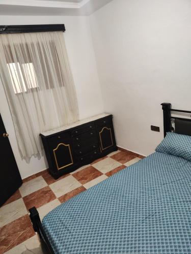 a bedroom with a bed and a dresser and a window at Lovely and comfortable apartment in Martil in Martil