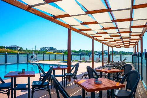 a patio with tables and chairs next to a pool at ivy Hotel Spa in Yalova