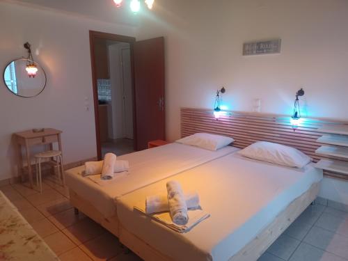 a bedroom with a large white bed with two towels at Tassos & Marios Apartments II in Alikanas
