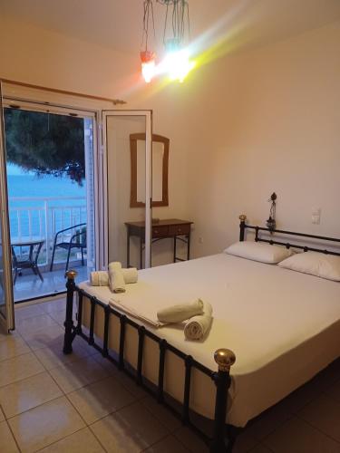 a bedroom with a bed with a view of the ocean at Tassos & Marios Apartments II in Alikanas