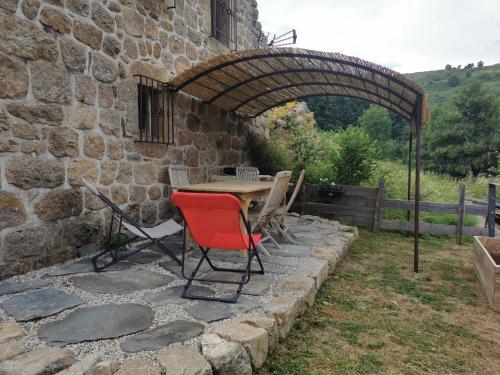 a table and chairs sitting under an archway at la pause nature in Saint-Martial