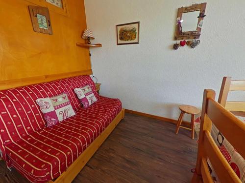 - un salon avec un canapé rouge dans l'établissement Studio cabine pour 4 personnes avec balcon exposé sud, au cœur des Saisies - FR-1-594-108, à Hauteluce
