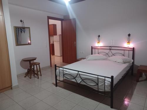a bedroom with a bed and a table and a stool at Tassos & Marios Apartments II in Alikanas