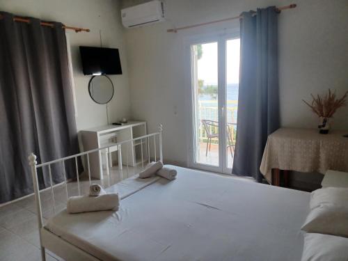 a bedroom with a bed and a window with a view at Tassos & Marios Apartments II in Alikanas