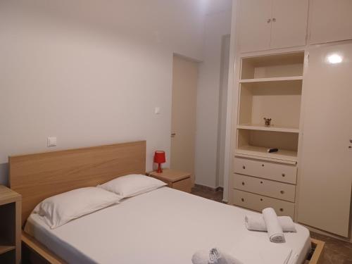 a bedroom with a white bed and a dresser at Tassos & Marios Apartments II in Alikanas