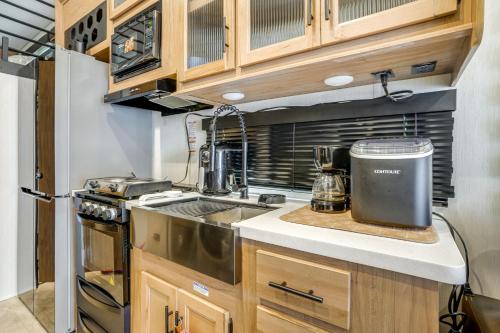 a kitchen with wooden cabinets and a counter top at 10 Mi to Leesylvania and River Sleek Mobile Home in Woodbridge