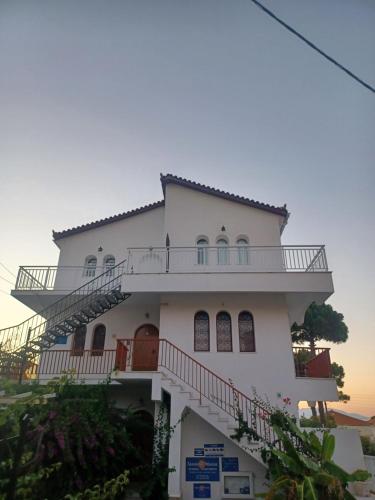 a white house with balconies on top of it at Tassos & Marios Apartments II in Alikanas