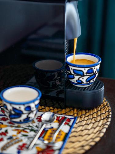 a coffee being poured into two cups on a table at Sol Hotel Haifa in Haifa
