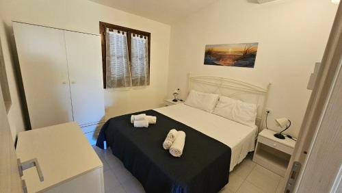 a bedroom with a bed with two towels on it at San Teodoro Beach Villa 86b in San Teodoro