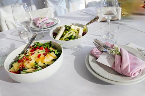 a white table with three bowls of food on it at EONA BEACH RESORT by Greek Pride in Skála Neón Epivatón