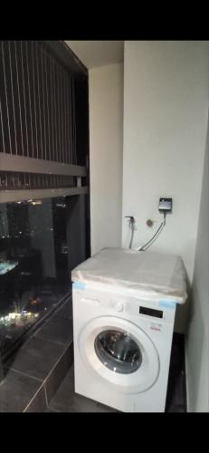 una lavadora blanca en una esquina de una habitación en Căn hộ Sunshine Center, en Hanói