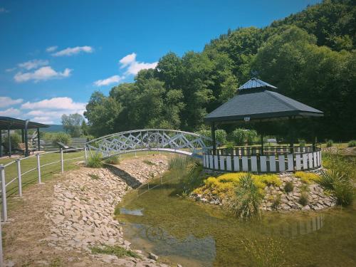 a bridge over a river with a gazebo at Domek w Dolinie Sanu in Witryłów
