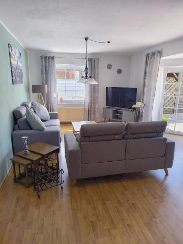 a living room with a couch and a tv at Ferienhaus Dini, 25668 in Weener