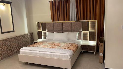 a bedroom with a large bed with a large headboard at Peace Palace Islamabad in Islamabad
