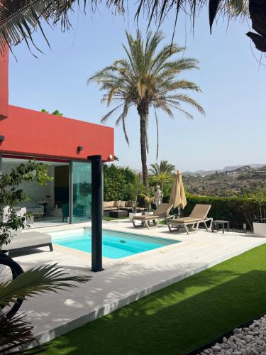 una villa con piscina y palmeras en VILLA Cooper l HEATED Pool l PVT Garden I GOLF I SEA VIEWS, en San Bartolomé