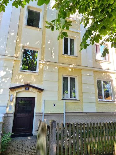 a yellow and white building with a black door at Leo11 in Traunstein