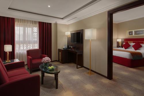 a hotel room with a bed and a living room at Millennium Taiba Hotel in Al Madinah