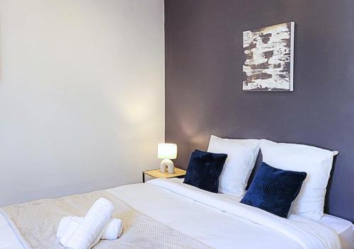 a bedroom with a bed with blue and white pillows at Le Gentil 'Home - Hypercentre - proche Cathédrale in Évreux