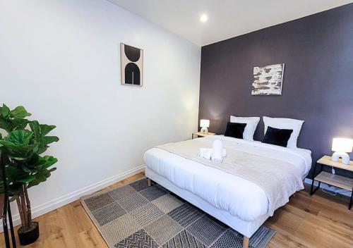 a bedroom with a large white bed with two lamps at Le Gentil 'Home - Hypercentre - proche Cathédrale in Évreux