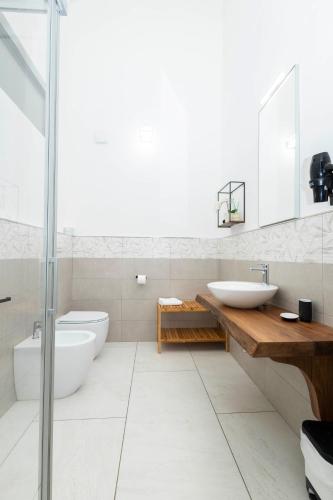 a white bathroom with two sinks and a shower at La Pineta del Borgo in Ravenna