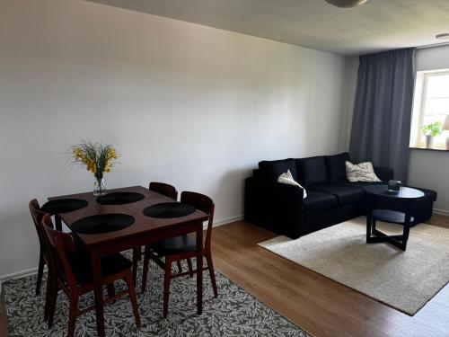a living room with a table and a couch at Hallands Equestrian Lägenhet in Laholm