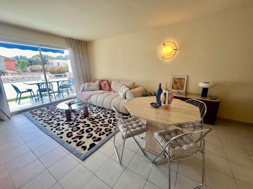 滨海卡瓦莱尔Appartement rénové 1 chambre à Cavalaire, proche plage, climatisé avec parking - FR-1-226B-107的客厅里有一张沙发和一张桌子。